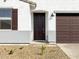 Close up of front entrance featuring a stylish dark-colored door and desert landscaping at 16038 W Desert Hollow Dr, Surprise, AZ 85387