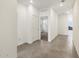 Bright hallway featuring tile flooring, white walls, and seamless access to other rooms at 16038 W Desert Hollow Dr, Surprise, AZ 85387