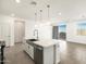 Modern kitchen featuring an island with pendant lighting, stainless steel appliances, and tile flooring at 16038 W Desert Hollow Dr, Surprise, AZ 85387