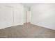 Neutral carpet in a bedroom featuring a closet with sliding doors and fresh white paint at 17672 W Pierson St, Goodyear, AZ 85395