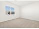 An empty bedroom has neutral carpet and bright natural light from a large window at 17672 W Pierson St, Goodyear, AZ 85395