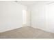 Empty bedroom featuring neutral carpeting, white walls, and double door closet for ample space at 17672 W Pierson St, Goodyear, AZ 85395