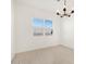 Bright dining room featuring modern chandelier, neutral tile floors, and a window providing natural light at 17672 W Pierson St, Goodyear, AZ 85395