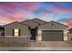 Charming single-story home with a two-car garage and a secure gated front entrance under colorful sky at 17672 W Pierson St, Goodyear, AZ 85395