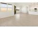 Bright living room with recessed lighting, neutral tile floors, and a seamless flow to the kitchen area at 17672 W Pierson St, Goodyear, AZ 85395