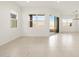 Bright and airy living room with recessed lighting, neutral tile floors, and sliding glass doors to the outdoor patio at 17672 W Pierson St, Goodyear, AZ 85395