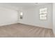 Bright bedroom with neutral carpeting and two windows at 18350 W Poston Dr, Surprise, AZ 85387