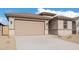 One story home with tan exterior and a two-car garage at 18350 W Poston Dr, Surprise, AZ 85387