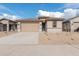 Tan one-story house with a two-car garage and desert landscaping at 18350 W Poston Dr, Surprise, AZ 85387