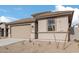 One story home with tan exterior, two-car garage, and desert landscaping at 18350 W Poston Dr, Surprise, AZ 85387