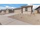 New construction home with tan exterior and two-car garage at 18350 W Poston Dr, Surprise, AZ 85387