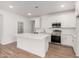 Modern kitchen with white cabinets, stainless steel appliances, and an island at 18350 W Poston Dr, Surprise, AZ 85387