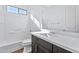 Bathroom with dark vanity, white tile, and a bathtub at 27112 N 148Th Dr, Surprise, AZ 85387