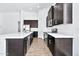 Modern kitchen with dark cabinetry, stainless steel appliances, and white countertops at 27112 N 148Th Dr, Surprise, AZ 85387