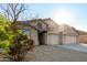 Tan three-car garage home with desert landscaping and tree at 43205 W Askew Dr, Maricopa, AZ 85138