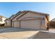 Tan three-car garage home with desert landscaping at 43205 W Askew Dr, Maricopa, AZ 85138