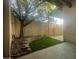 Enclosed patio area with retaining wall, artificial turf, mature tree, and covered area at 910 N Center St # 24, Mesa, AZ 85201