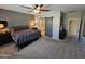 Bedroom features neutral carpet, ceiling fan, en-suite bathroom, and two round mirror accents at 926 W Ayrshire Trl, San Tan Valley, AZ 85143