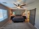 Stylish bedroom with neutral carpet, a ceiling fan, and a modern barn door leading to the bathroom at 926 W Ayrshire Trl, San Tan Valley, AZ 85143