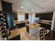 Spacious kitchen featuring dark cabinets, granite countertops and a center island with bar seating at 926 W Ayrshire Trl, San Tan Valley, AZ 85143