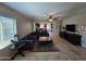 Spacious living room featuring a plush sectional, stylish rug, and an open layout leading to the dining area at 926 W Ayrshire Trl, San Tan Valley, AZ 85143