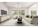 Bright living room featuring large windows, neutral tones, and modern chandelier at 21067 N Sequoia Crest N Dr, Surprise, AZ 85387