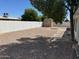A spacious backyard with gravel features a shed at the end of the yard at 5232 E Dodge St, Mesa, AZ 85205