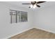 Empty bedroom with light-colored wood floors, a window, and fresh paint at 5232 E Dodge St, Mesa, AZ 85205