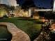 Night view of a backyard with a pool and lush landscaping at 8336 E Sunnyside Dr, Scottsdale, AZ 85260