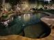 Night view of a freeform swimming pool with stone coping and landscaping at 8336 E Sunnyside Dr, Scottsdale, AZ 85260