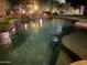 Night view of a freeform swimming pool with stone coping at 8336 E Sunnyside Dr, Scottsdale, AZ 85260