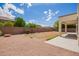 Expansive backyard features a covered patio, neutral landscaping, and block fencing providing privacy and space for outdoor activities at 10101 E Posada Ave, Mesa, AZ 85212