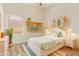 The brightly-colored bedroom is decorated with shelving, a plant, and a bed at 10101 E Posada Ave, Mesa, AZ 85212