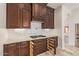 Kitchen featuring dark wood cabinets with granite countertops and a subway tile backsplash with pull-out storage at 10101 E Posada Ave, Mesa, AZ 85212