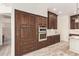 Kitchen boasting dark wood cabinets, stainless steel appliances, granite countertops, and wood-look tile flooring at 10101 E Posada Ave, Mesa, AZ 85212