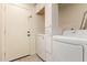 This laundry room has ample cabinet space and modern washer and dryer units at 10101 E Posada Ave, Mesa, AZ 85212
