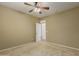 Comfortable carpeted bedroom featuring a ceiling fan and a doorway leading to another area at 12121 W Patrick Ln, Sun City, AZ 85373