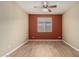 Spacious bedroom showcasing hardwood floors, a ceiling fan, and a large window for natural light at 12121 W Patrick Ln, Sun City, AZ 85373