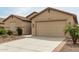 Well-maintained single-story home showcasing a spacious driveway, two-car garage, and neat front yard at 12121 W Patrick Ln, Sun City, AZ 85373