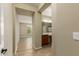Hallway view with a bathroom featuring a vanity and a view into a well-lit living space at 12121 W Patrick Ln, Sun City, AZ 85373