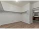 A sizable walk-in closet with shelving and wood look flooring is conveniently located next to the primary bathroom at 12121 W Patrick Ln, Sun City, AZ 85373
