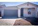 Charming single-story home featuring a two-car garage, desert landscaping, and a decorative cross gable adornment at 5419 W Las Palmaritas Dr, Glendale, AZ 85302