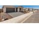 Charming single-Gathering home with a gray garage door, a paved driveway, and well-maintained landscaping at 5419 W Las Palmaritas Dr, Glendale, AZ 85302