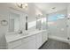 Bright bathroom has double sinks, quartz countertops, and a shower with glass doors and marbled walls at 13634 S 192Nd Ave, Buckeye, AZ 85326