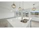 Kitchen island featuring a double sink, modern faucet, and pendant lighting, with a scenic view at 13634 S 192Nd Ave, Buckeye, AZ 85326