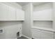 The laundry room has cabinets above the washer and dryer, countertops for folding clothes, and wood flooring at 13634 S 192Nd Ave, Buckeye, AZ 85326