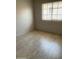 Bedroom showcasing a window with neutral blinds and modern wood-look flooring at 141 N Pasadena --, Mesa, AZ 85201