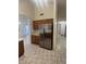 Kitchen with stainless steel refrigerator, tile flooring, archway, and wood cabinets for storage at 14543 W Bison Path, Surprise, AZ 85374