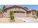Charming exterior with a two-car garage, desert landscaping, and decorative stone accents add to the curb appeal at 16468 W Mariposa Grande --, Surprise, AZ 85387