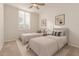 Bright bedroom with twin beds, a ceiling fan, and a large window for plenty of natural light at 21774 E Camacho Rd, Queen Creek, AZ 85142